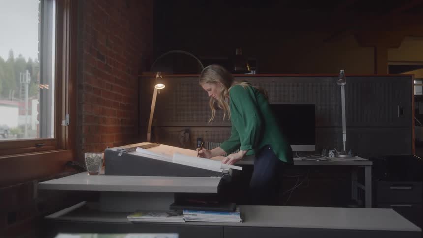 Woman architect sketching at drafting table
