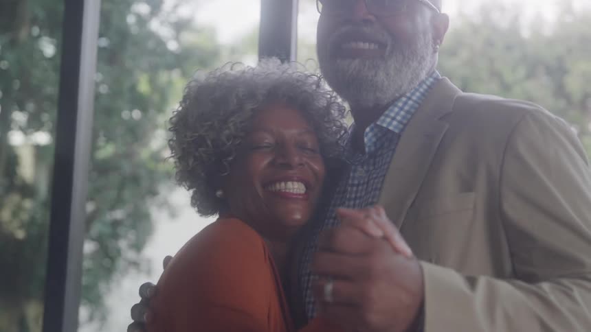 A man and woman smile while slowly dancing together