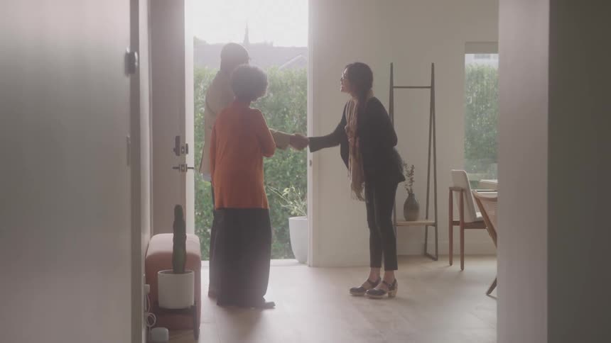 The realtor greets people at the door