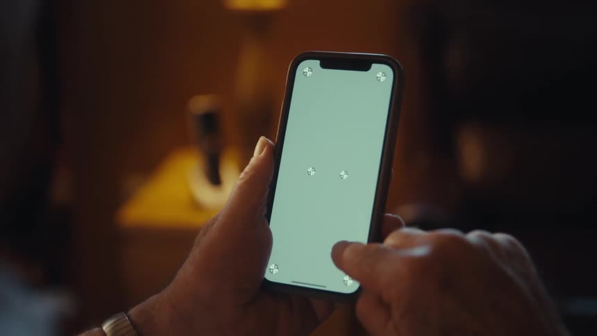 Man sitting at home scrolls on his smartphone