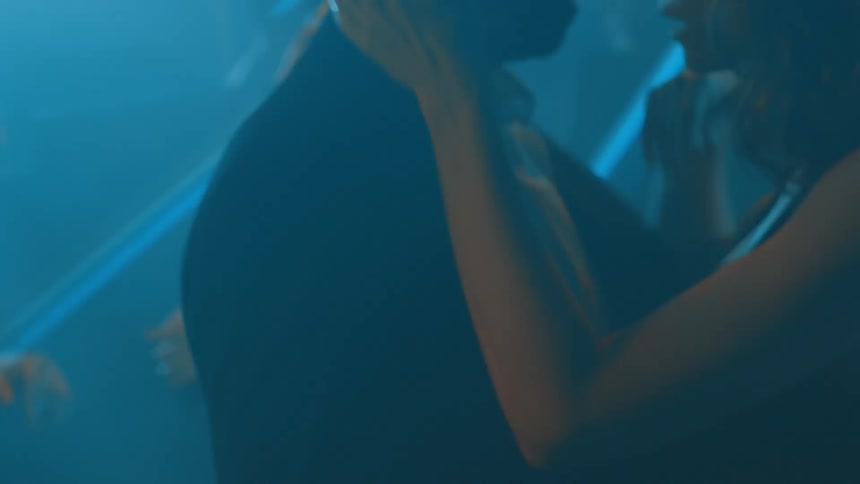 A couple dance and kiss at a dance club