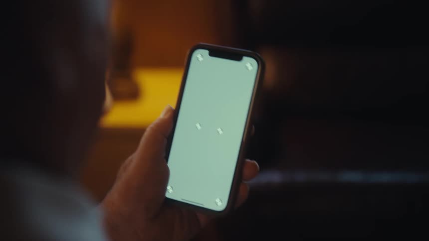 The man is sliding and tapping on his cell phone