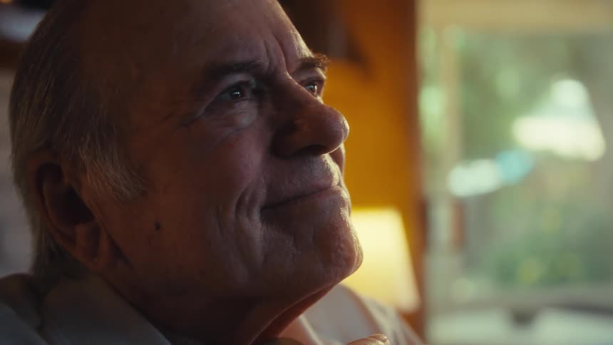 Elderly man holding a smartphone with happy expression