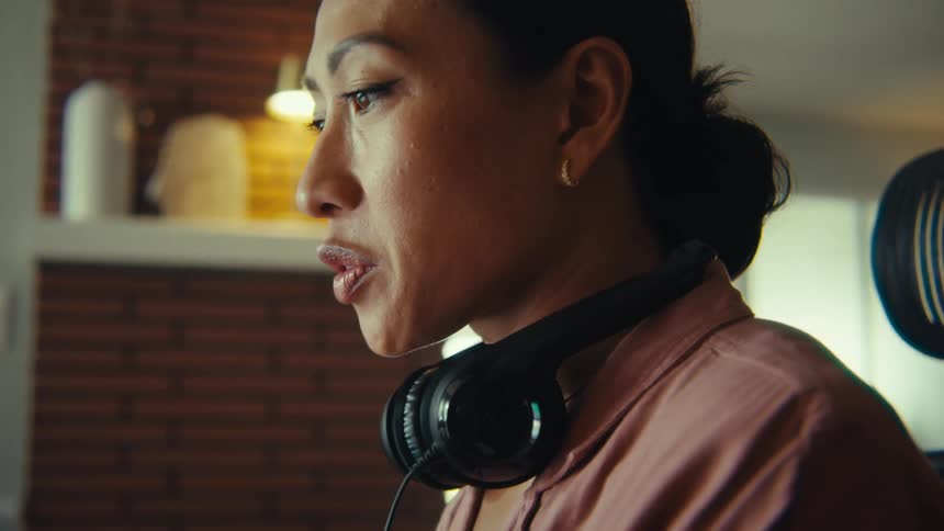 Woman with headphones around her neck sitting and talking