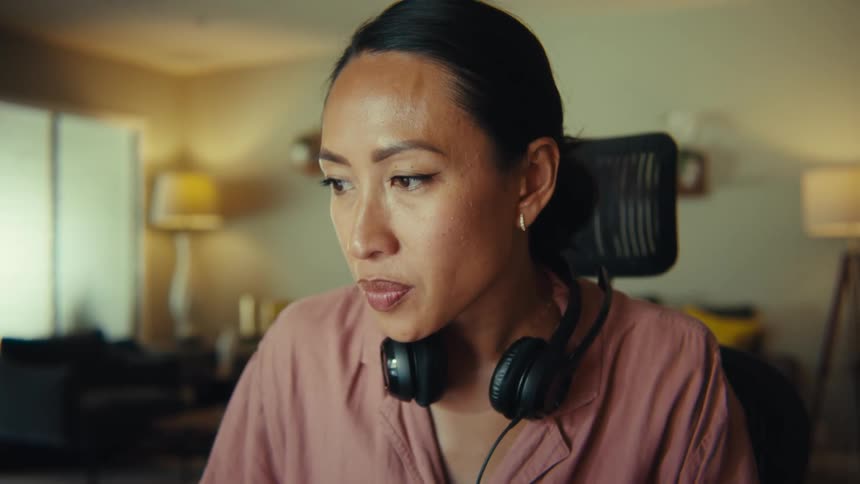 Woman sitting in a room with a concentrated expression