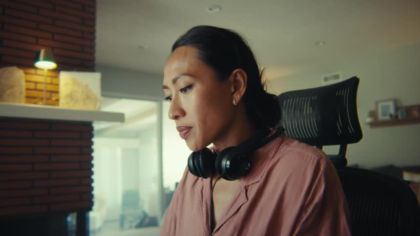 Woman sitting in a chair with headphones around her neck