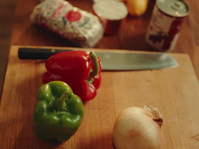 Wooden board with peppers and an onion