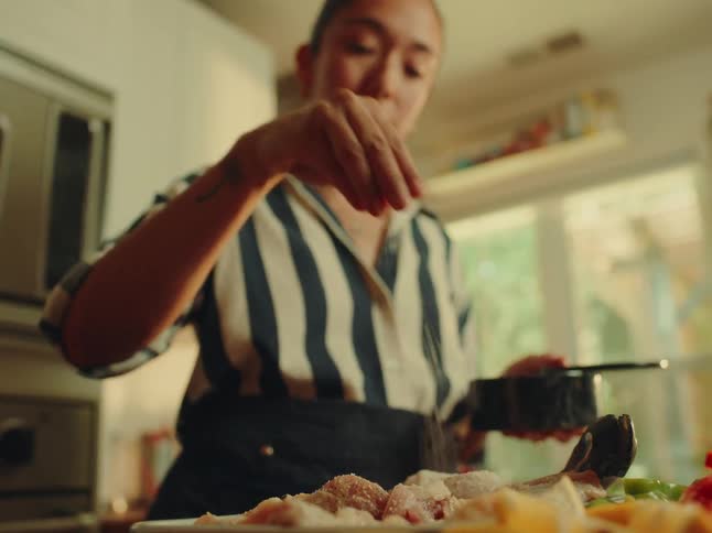 Woman seasoning a chicken with salt
