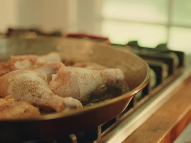 Chicken cooking in a pan on the stove