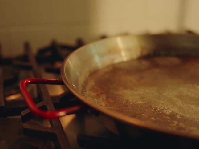 Close up of a frying pan placed on a gas cooker in the kitchen