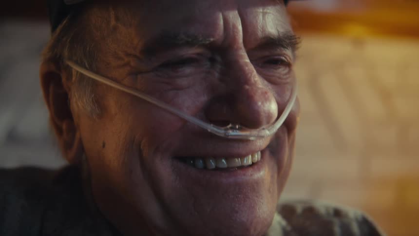 Elderly man with a thin tube in his nose breathing and smiling happily