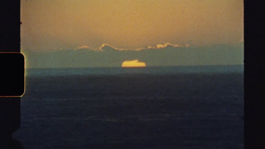 An ocean view at sunset with an orange skyline