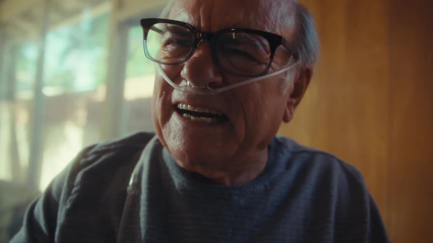 A man yells angrily as he looks at two pieces of paper