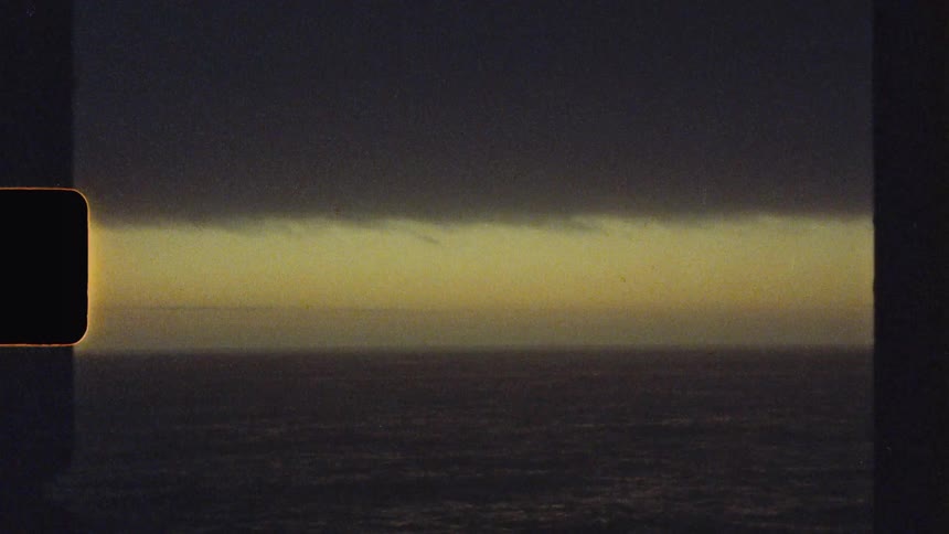 The video displays an abstract dark landscape with a bright horizontal band of light across the middle suggesting a distant horizon or atmospheric effect a single white dot possibly a star or distant light briefly appears above the band
