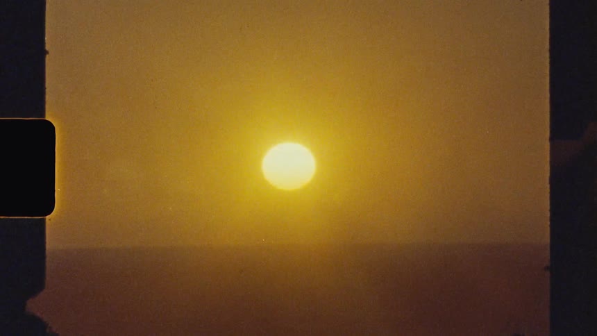 Sunset glows through dusty air between dark silhouettes