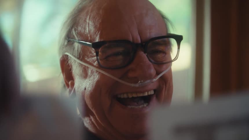 Elderly man with a small oxygen tube in his nose with a happy expression looking at the documents