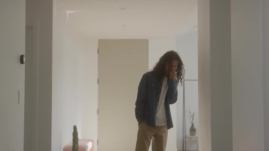 A man walks through a hallway looking little worried