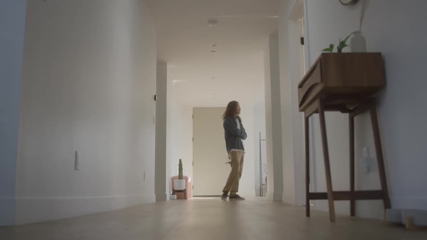 Person in the hallway of a house walking back and forth