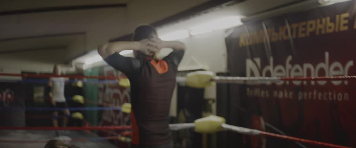 A man is walking around a wrestling ring