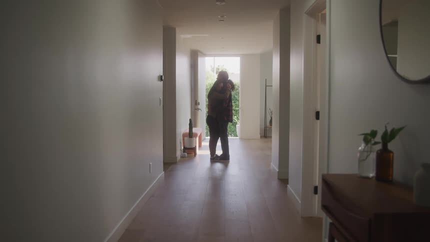 Couple hugging together in the hallway of the house