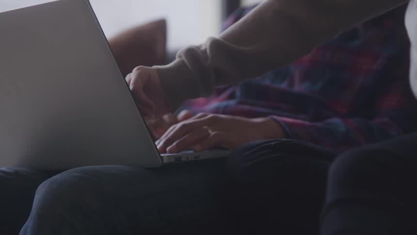 Hands of two people interacting with a laptop