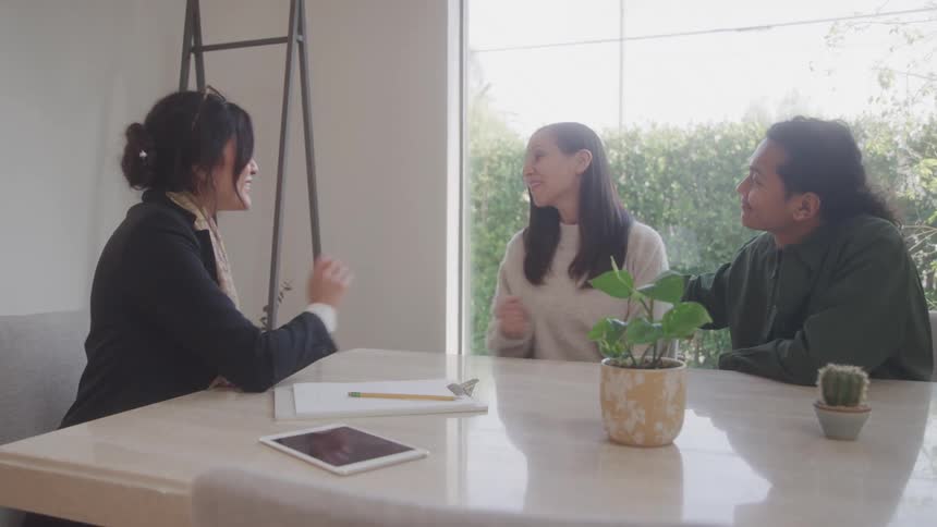 Female real estate agent handing over the keys to a house to a couple