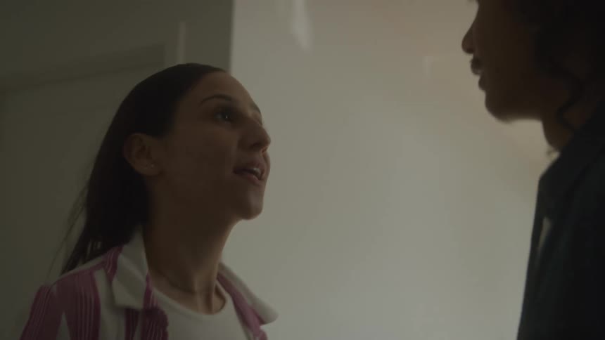 A couple argues in a dimly lit room