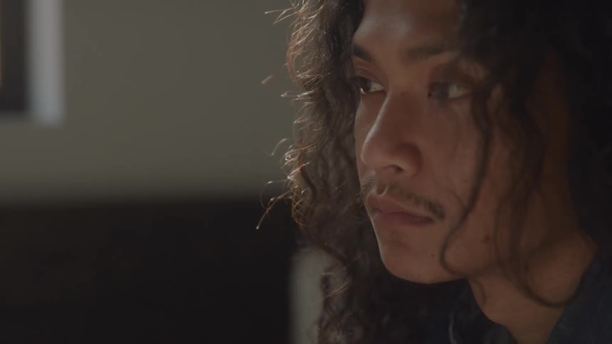 The face of a hairy man who has his eyes closed and then opens them and stands there staring at a point