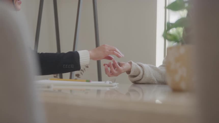 Key being handed to another person on a table