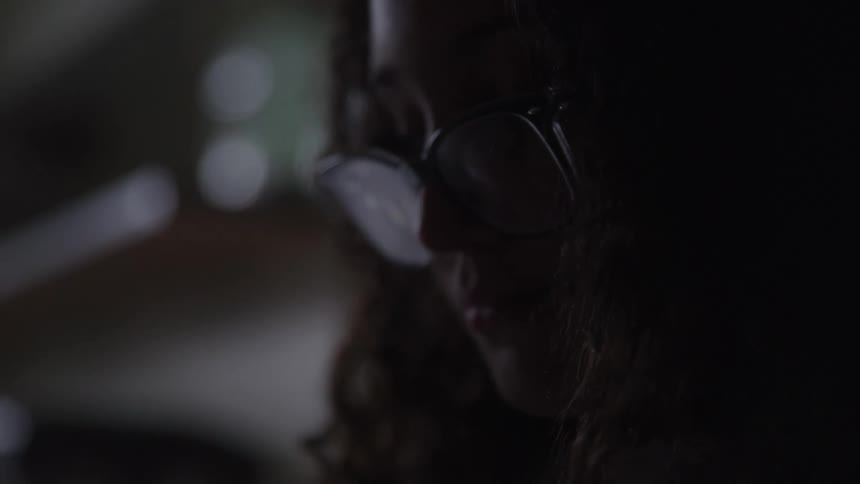 Woman with glasses and curly hair in an indoor space