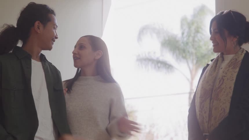 Woman in an indoor space talking to a couple