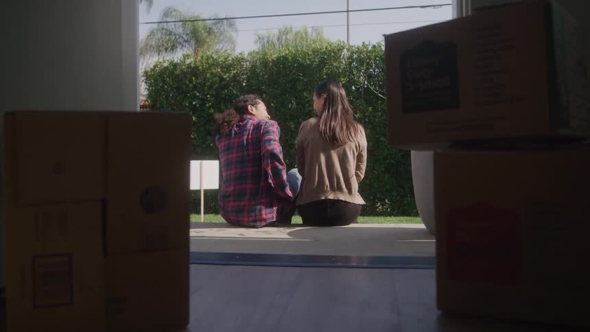 Couple sits together on doorstep sharing a quiet moment