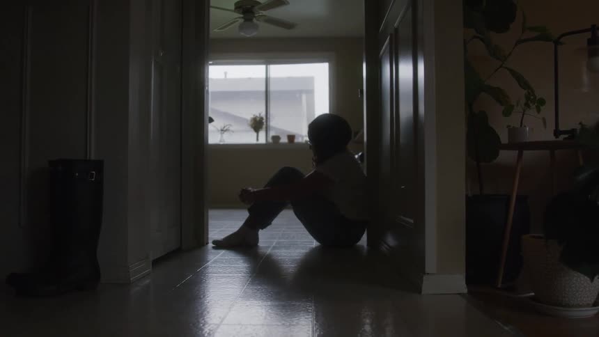Woman sitting on the floor of a houses hallway