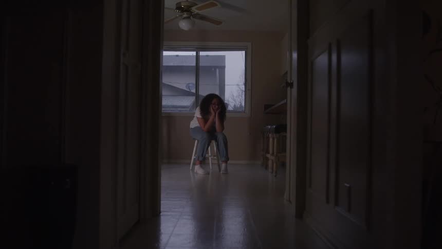 Woman sitting in an indoor space looking discouraged