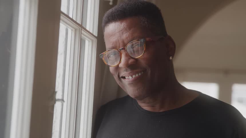 Portrait of a man wearing glasses with an earring and happy