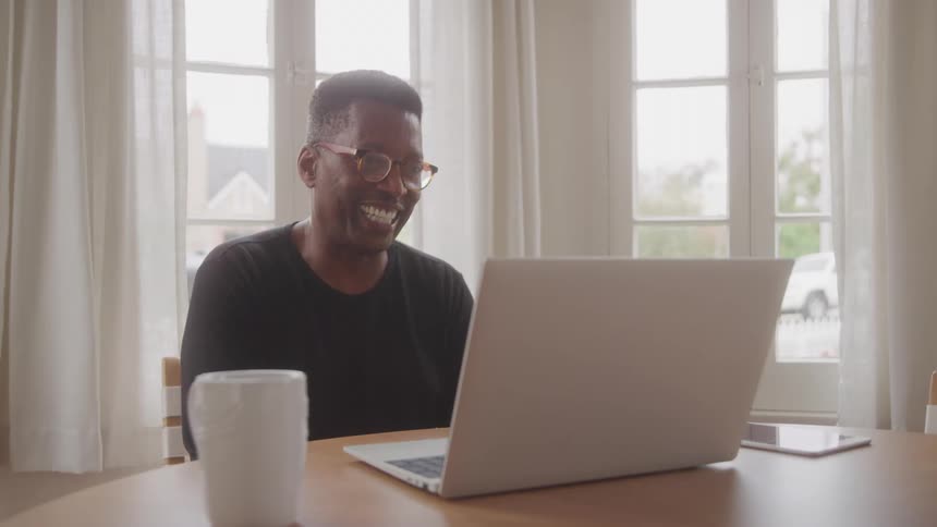 Man talking in front of a laptop on the table
