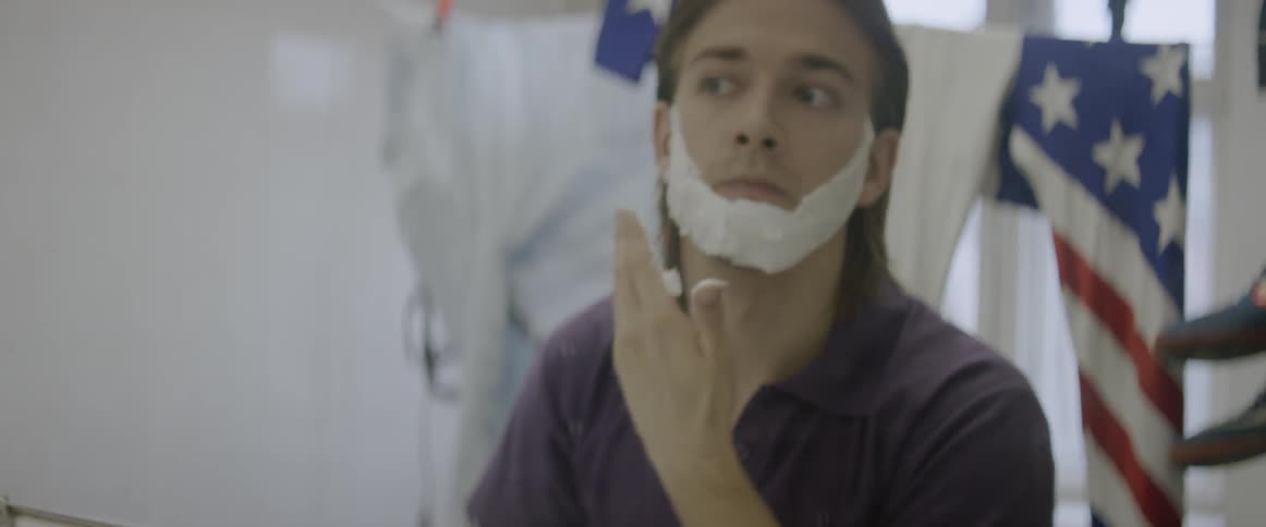 A man is applying shaving cream to his face