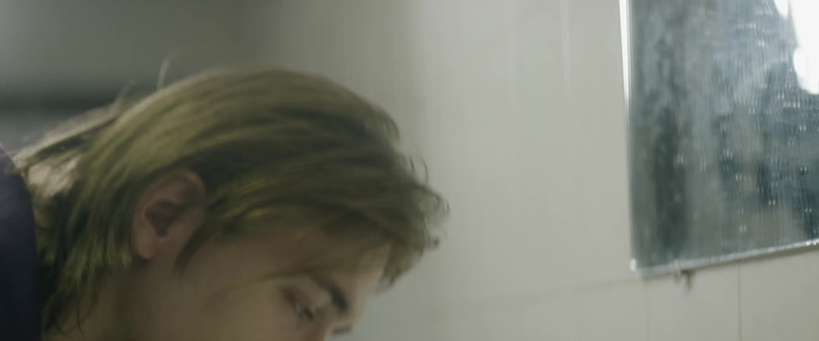 A man washes his face at a bathroom sink