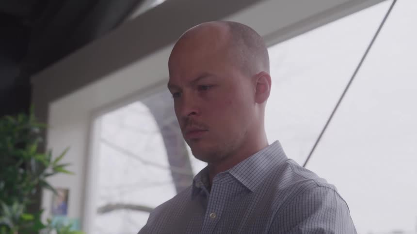 Bald man in a concentrated interior space