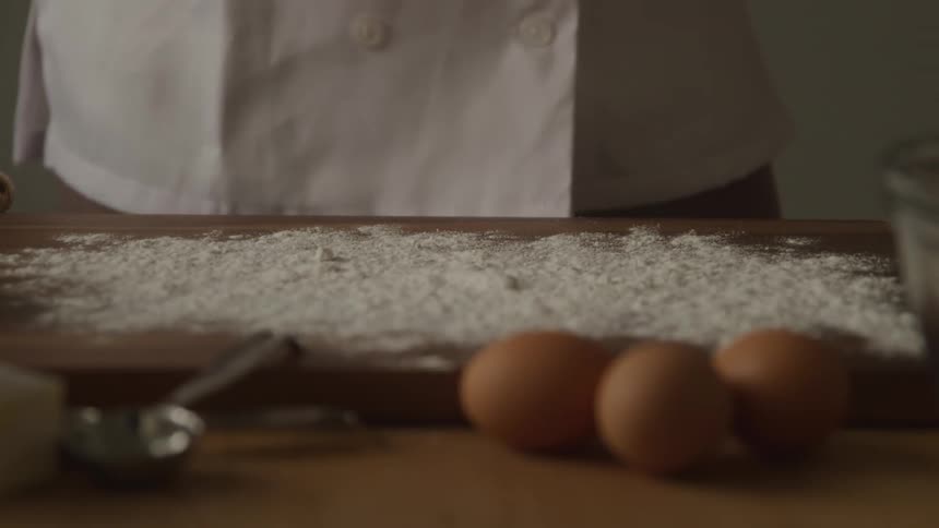 Eggs on a table near a cutting board covered in flour