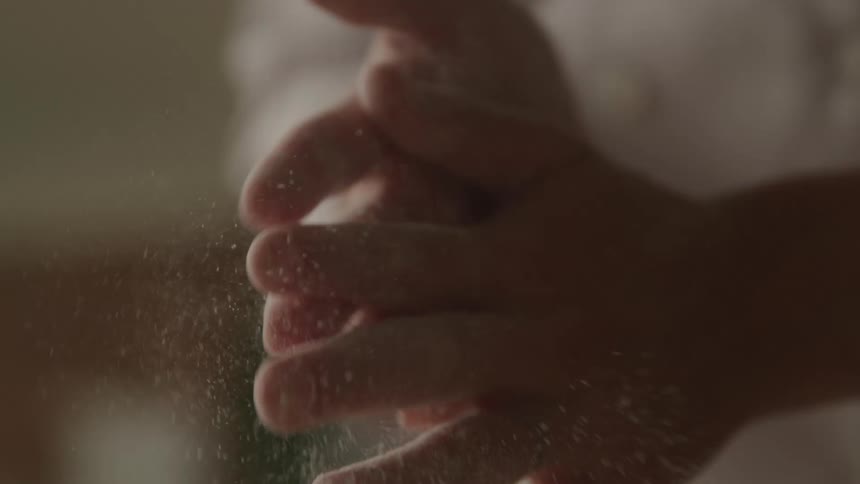 Person rubbing hands together brushing off flour