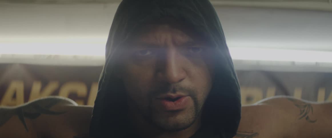 A man wearing a hood inhales and exhales deeply