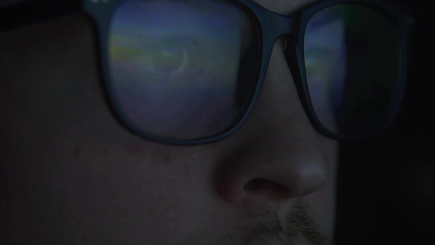 Portrait of a man wearing glasses with a reflection of a screen with no signal