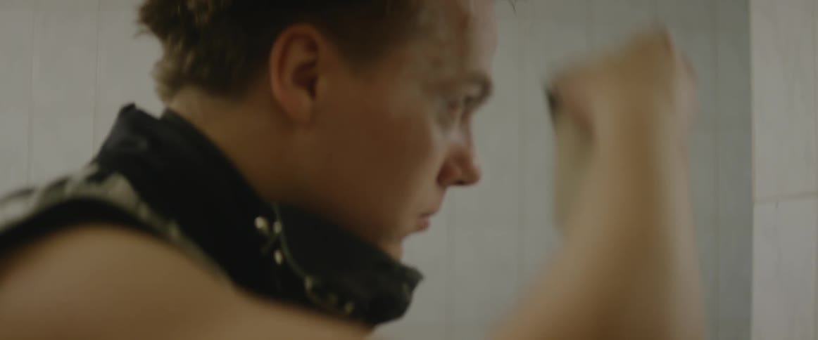 A man applies white makeup to his face