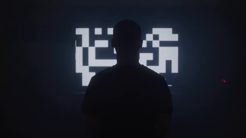 Silhouette of a person in a dark room with a chart on the wall