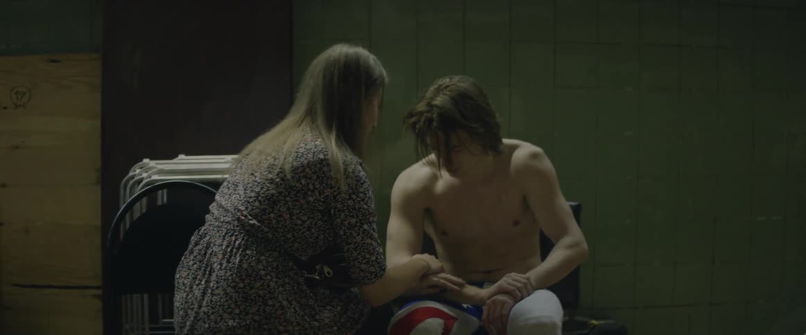 A woman comforts a man in a dressing room