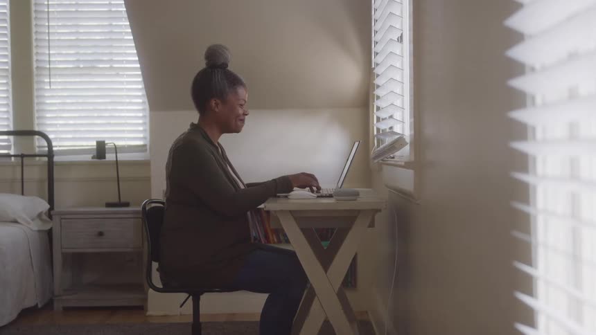 Woman sitting typing on a laptop