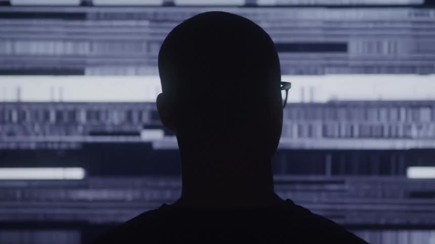 A silhouette of an adult males head is visible against a dark background with blue and purple horizontal and vertical digital lines that flicker and shift