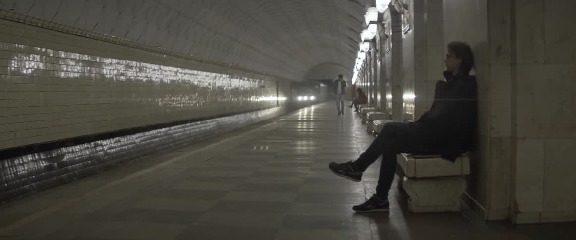 People wait for a train in an underground subway station