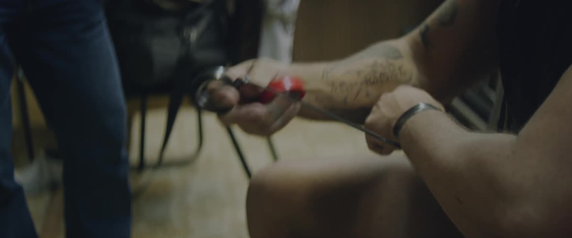 A man is taping up his wrists in a gym